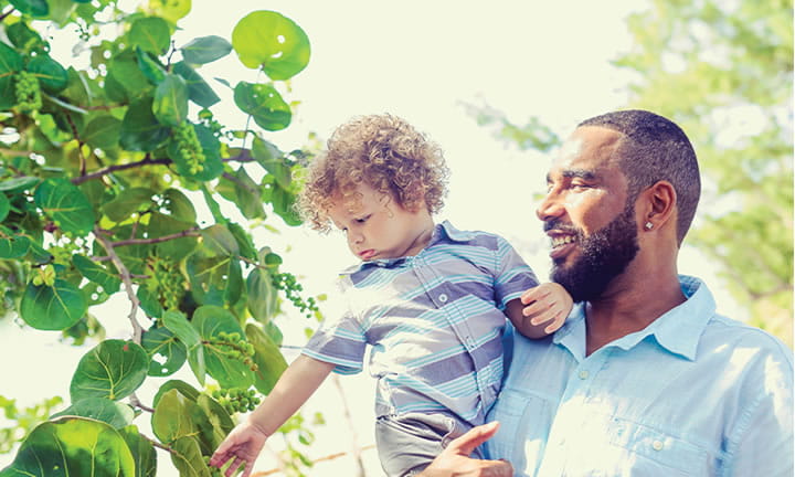 dad holding and smiling at child