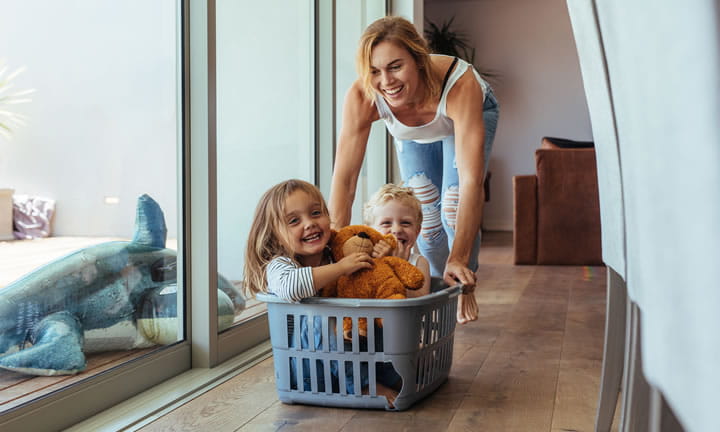mom pushing kids in laundry basket