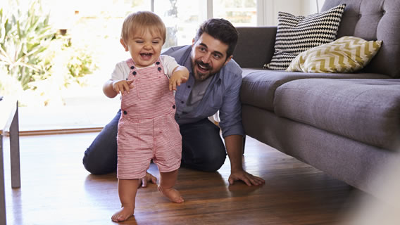 baby walking with father crawling behind