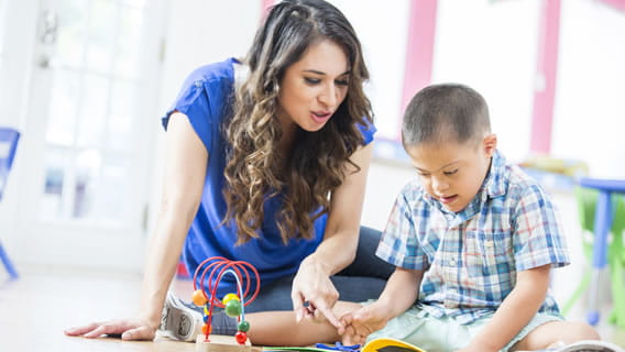 provider pointing at something in a book that child is reading