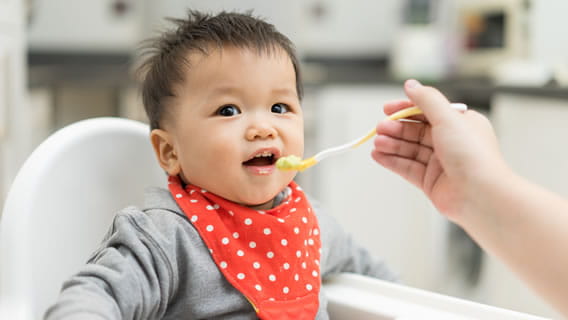 baby in high chair being fed