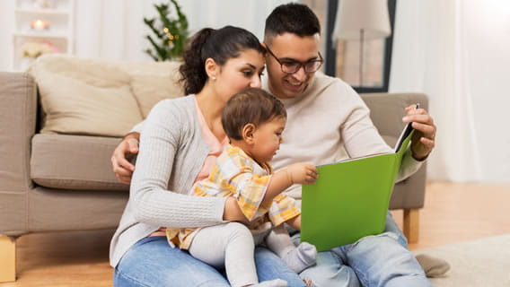 mom and dad reading to infant