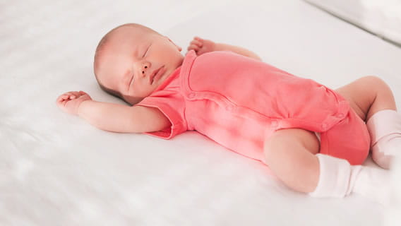 baby in safe sleep position in crib