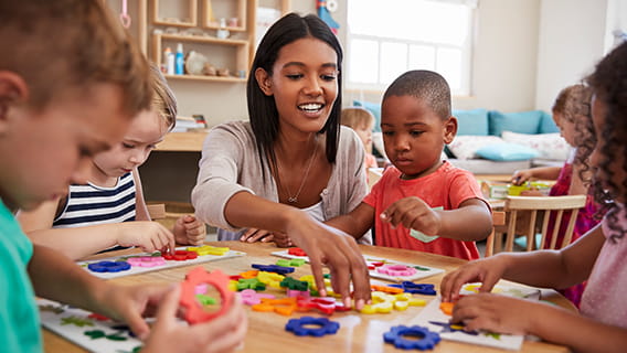 provider at table playing with shape toys with two preschoolers
