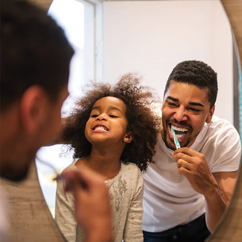 dad and daughter brushing teeth