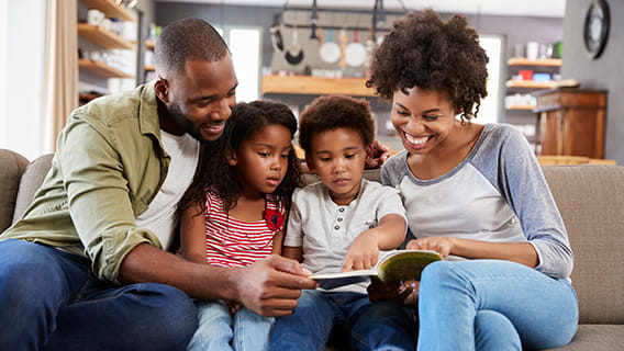mother and father reading to young son and daughter