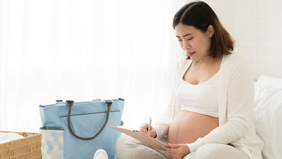 expectant mom going over checklist for overnight delivery bag