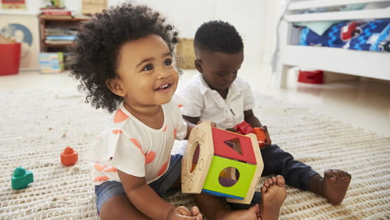 toddler boy and girl playing with shape toy
