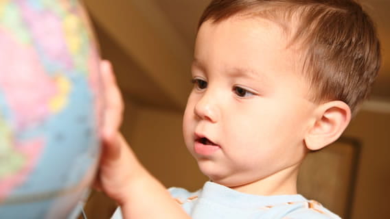 toddler playing with globe