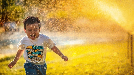toddler running through sprinklers