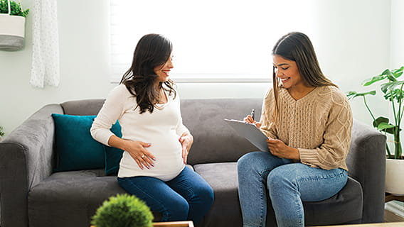 expectant mom on couch with nurse talking