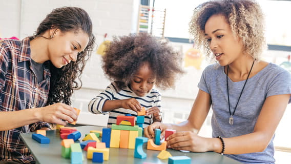 mom daughter and provider at a table playing with blocks