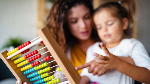 mom and young daughter using abacus
