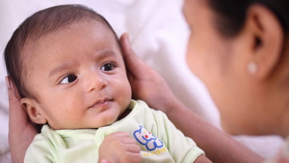 baby looking at mother