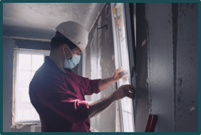 Construction worker wearing face mask while working inside a house
