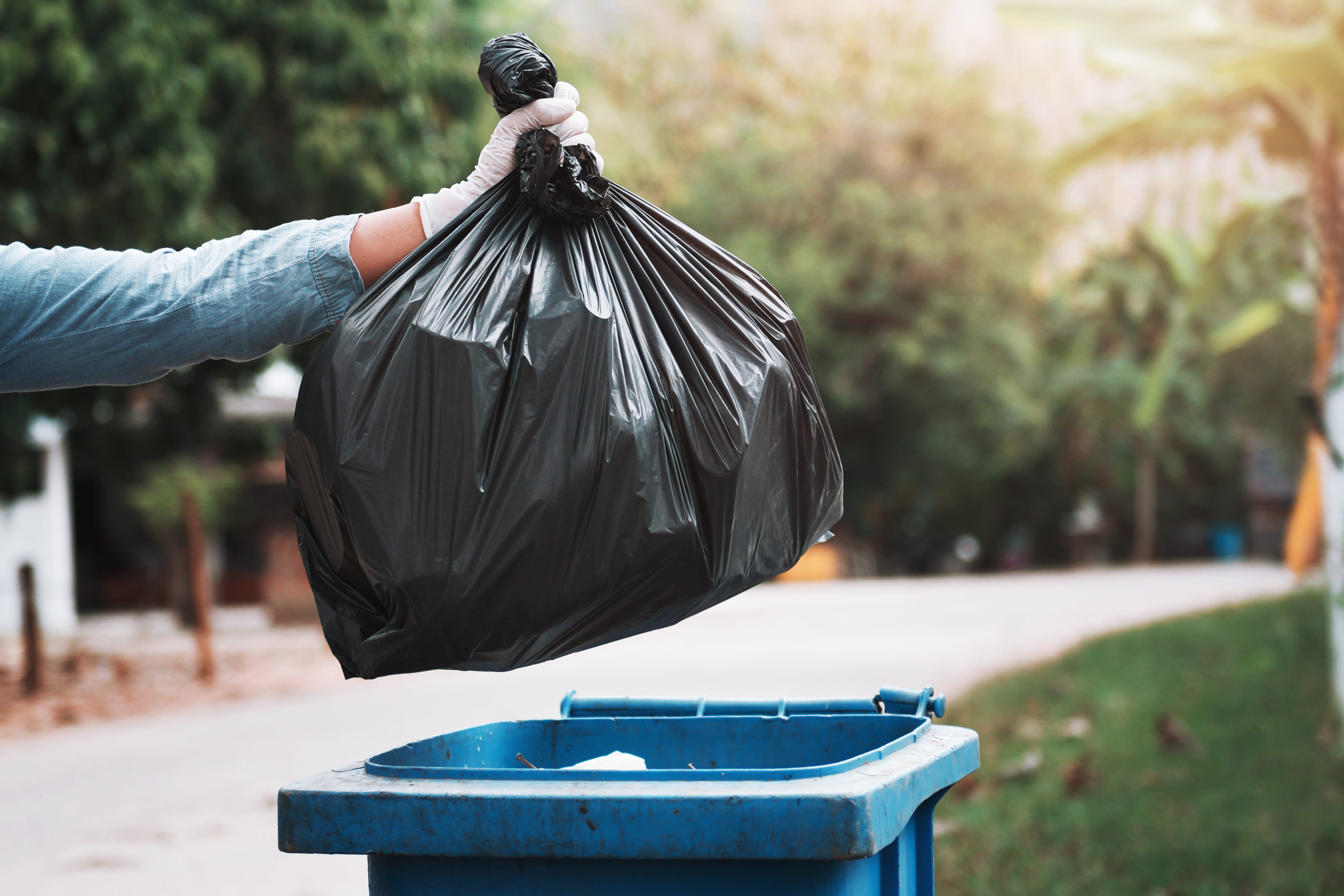 Trash bag being thrown away into container