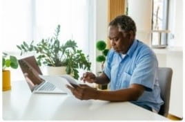 man with computer and paper