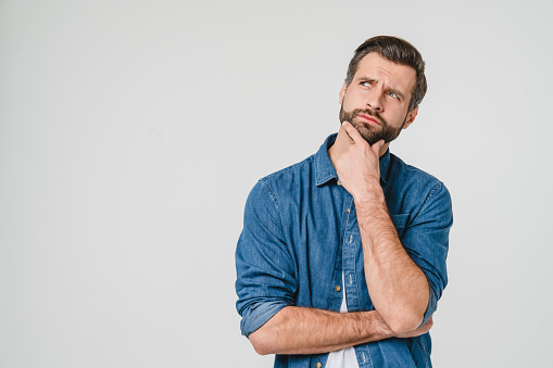 man placing hand under chin in thought