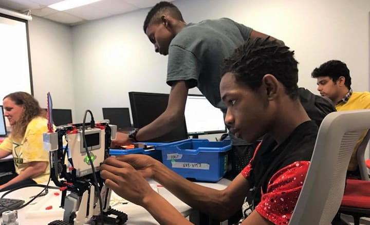 teenager in classroom making robot