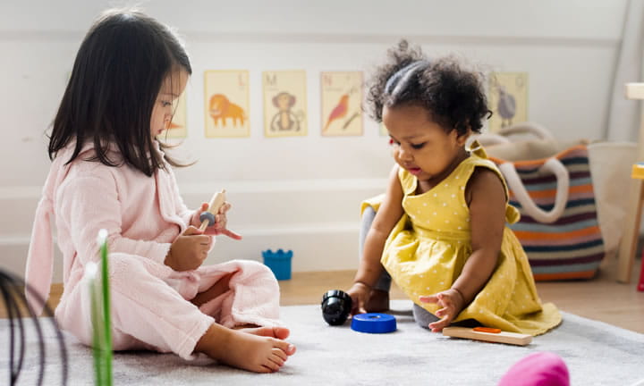 Two toddler girls playing in care setting