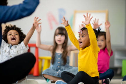 4 kids with arms raised