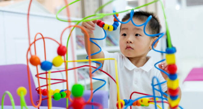boy playing with bead toy