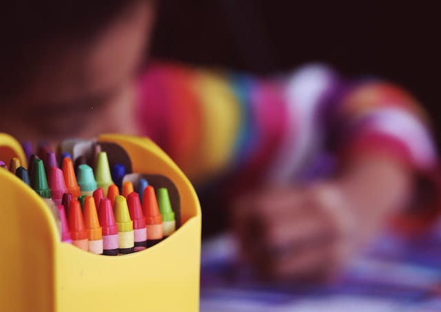 A child coloring with crayons