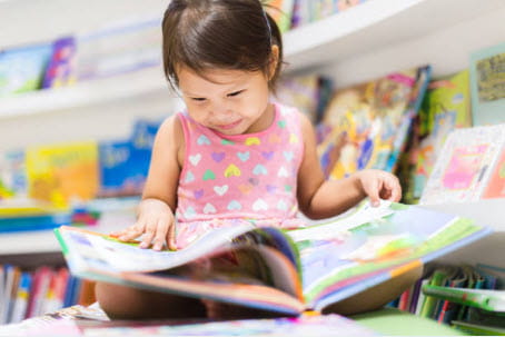 little girl reading a book