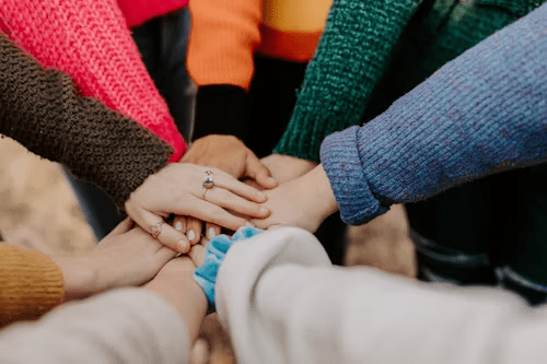 kids putting hands in a circle