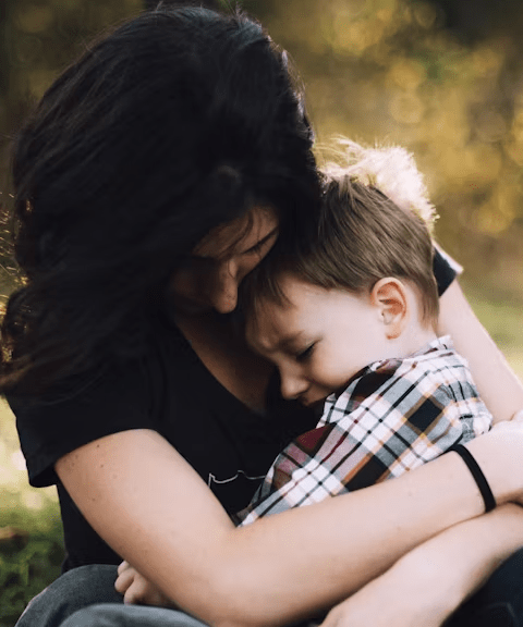 woman hugging boy on her lap