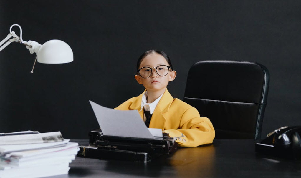 girl in yellow blazer at typewriter