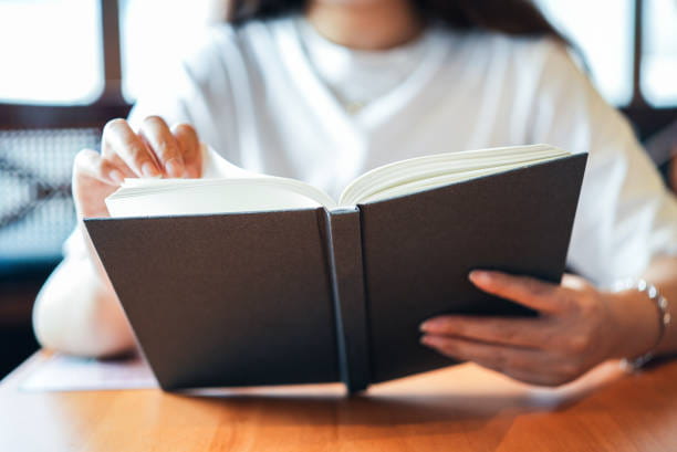 person reading book at table 
