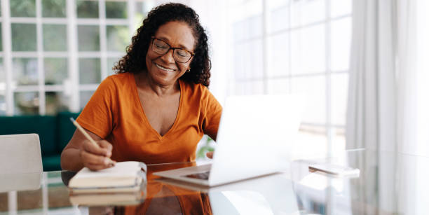 woman with a notepad and laptop on table 