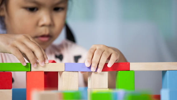 preschooler building a bridge with blocks