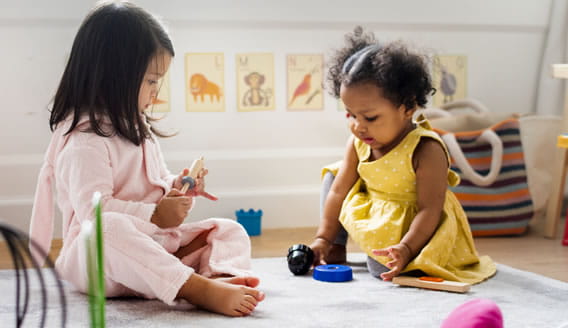 Two toddler girls playing in classroom setting