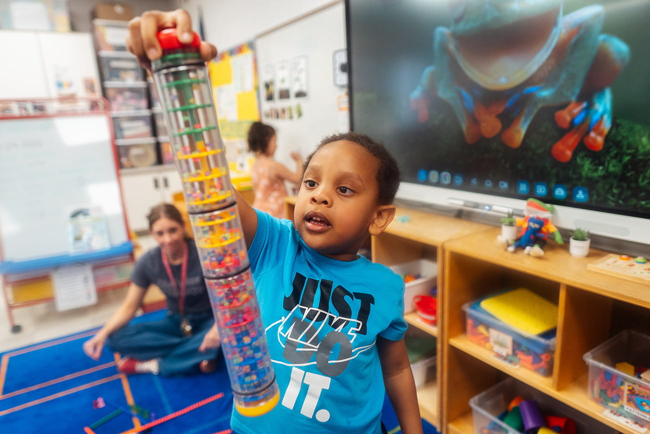 Close up of a young student playing with a toy in a preschool classroom setting