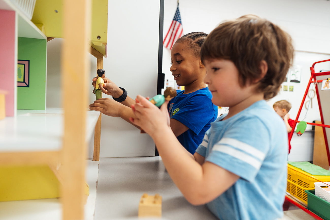 Close up of two young children playing side by side in a preschool classroom