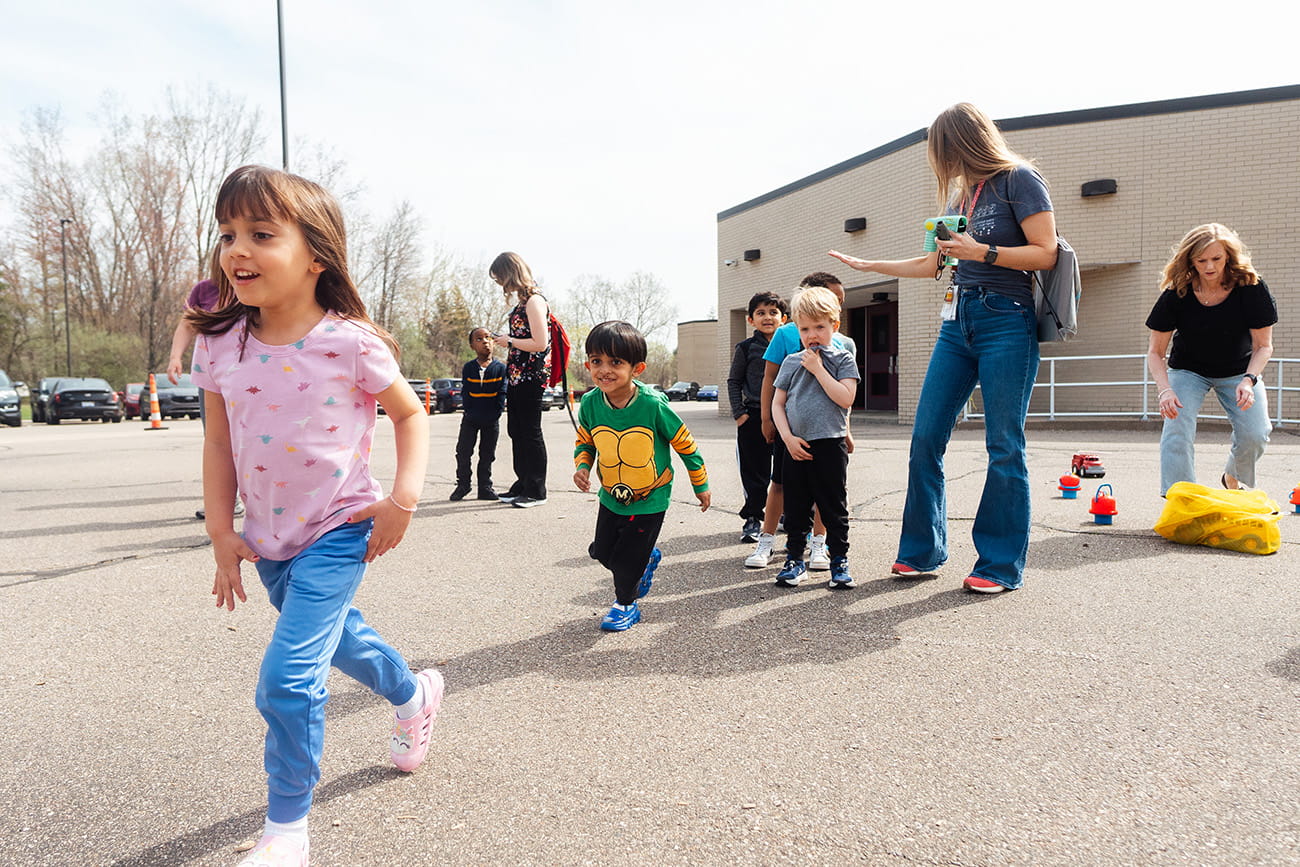 Preschool students walking outside with their teacher