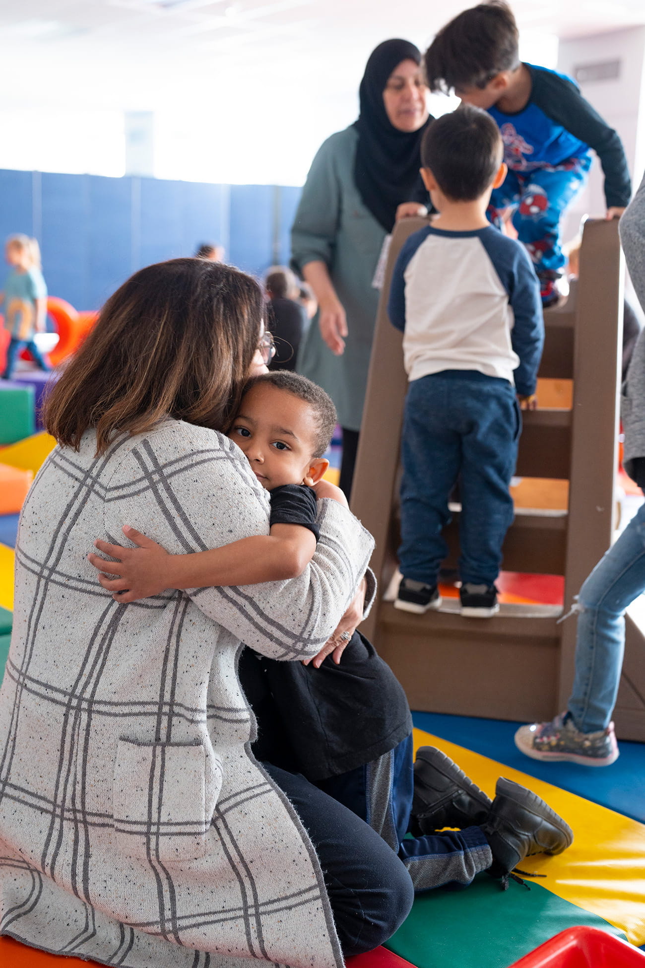 A teacher embracing a student in a preschool classroom setting
