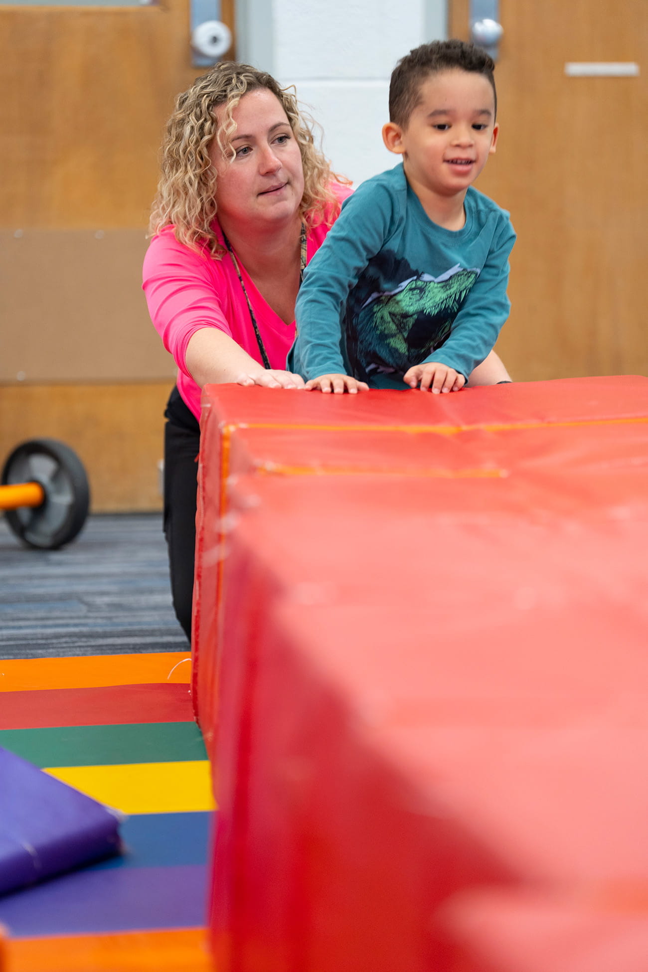 A teacher looking after a child playing indoors