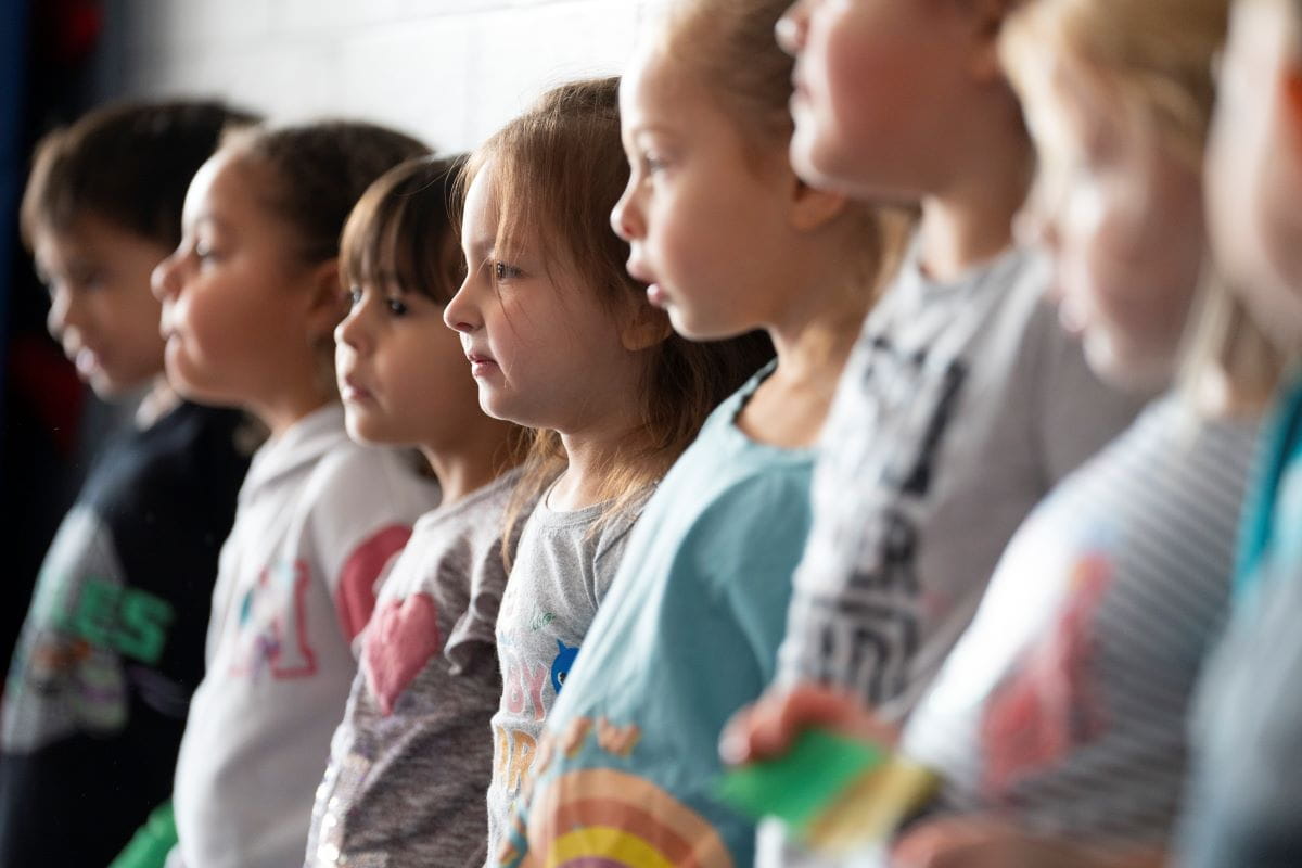 A silhouette shot of young students lined up against the wall