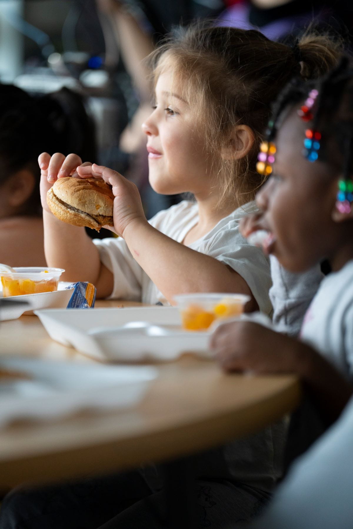 A close up of two young children eating at a table
