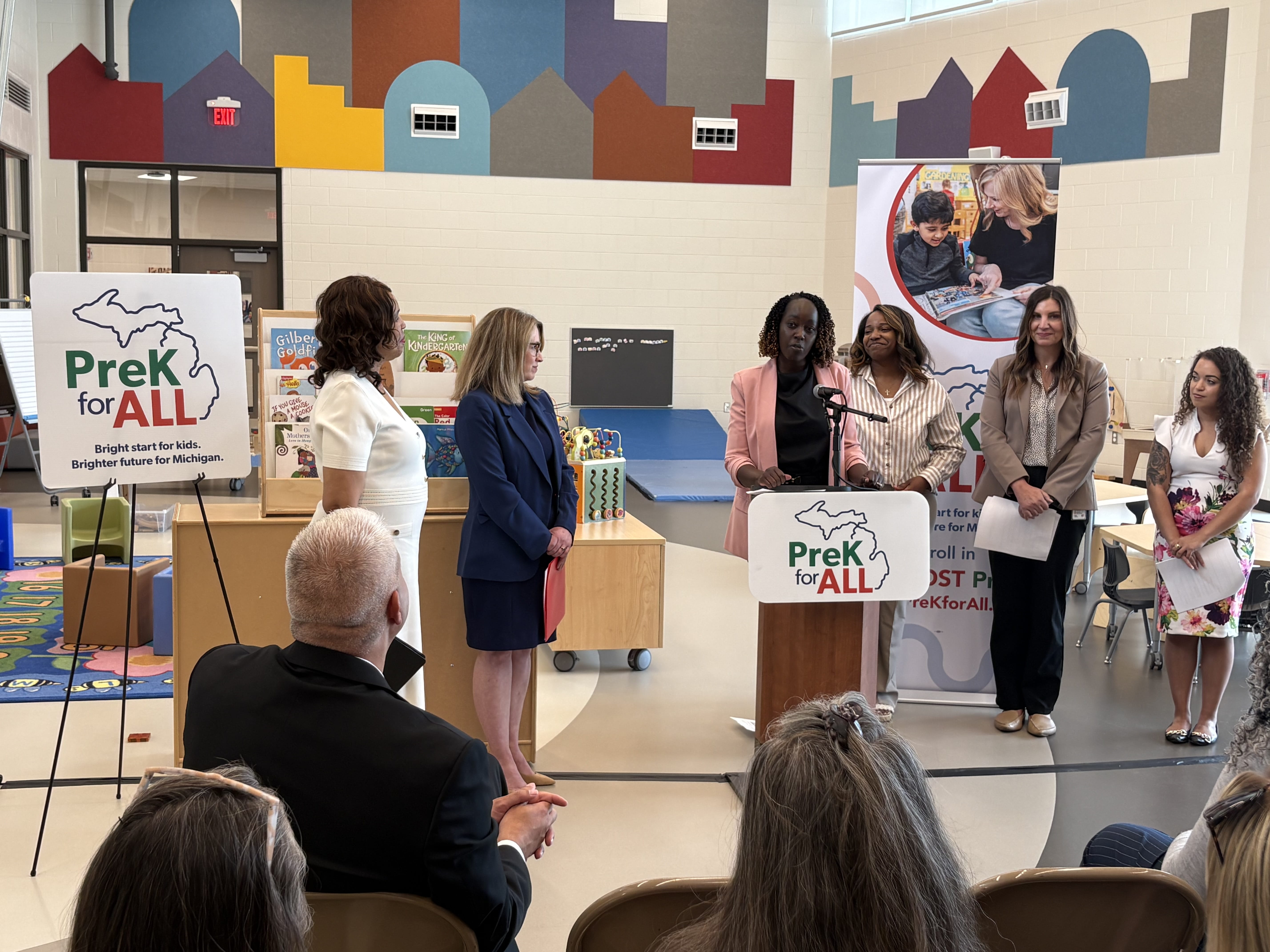 Crowd shot of Christie Cobbson stands at podium, speaking at PreK for All press event