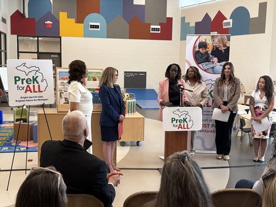 Crowd shot of Christie Cobbson stands at podium, speaking at PreK for All press event