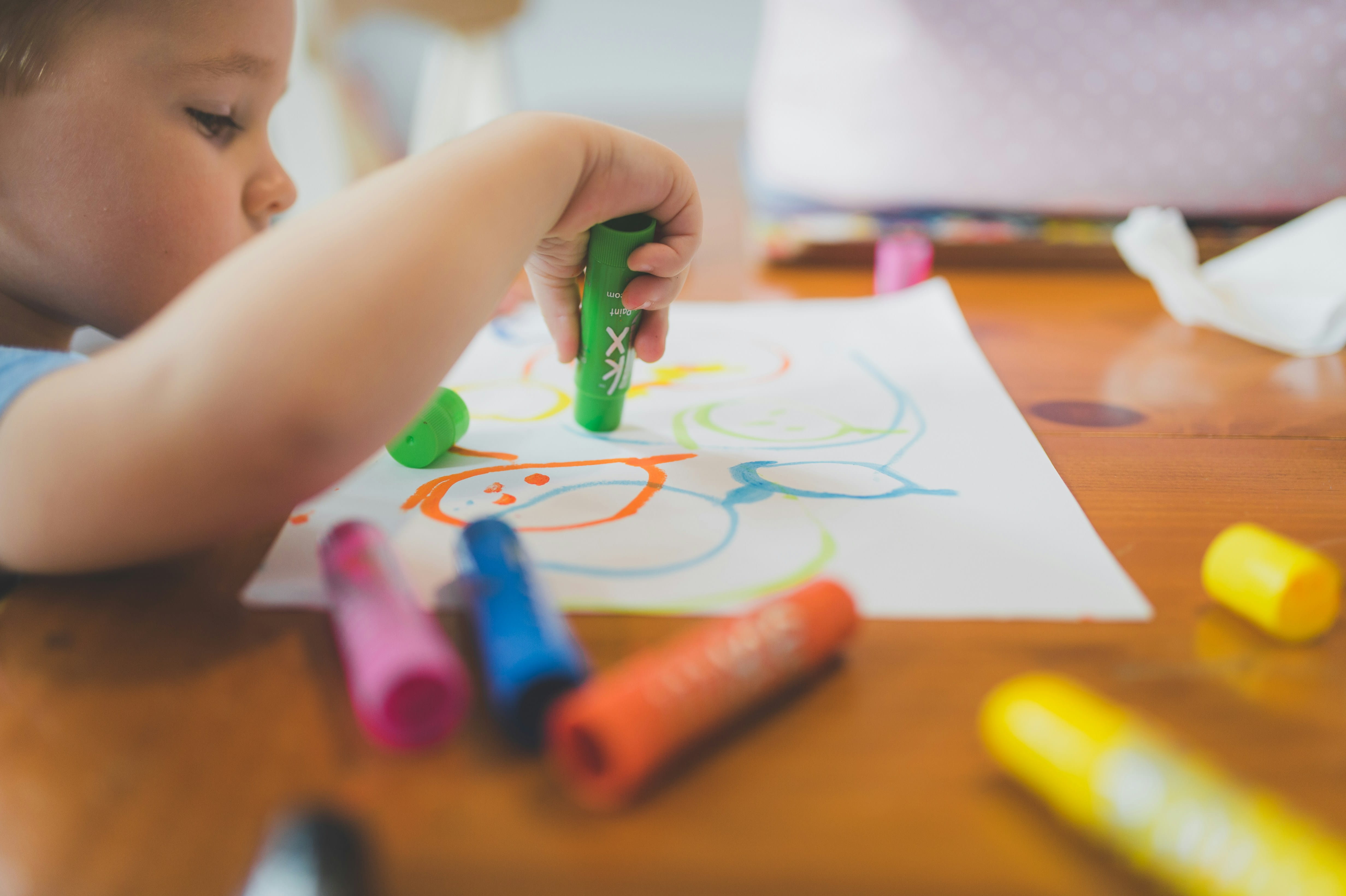 A student coloring on a piece of paper.