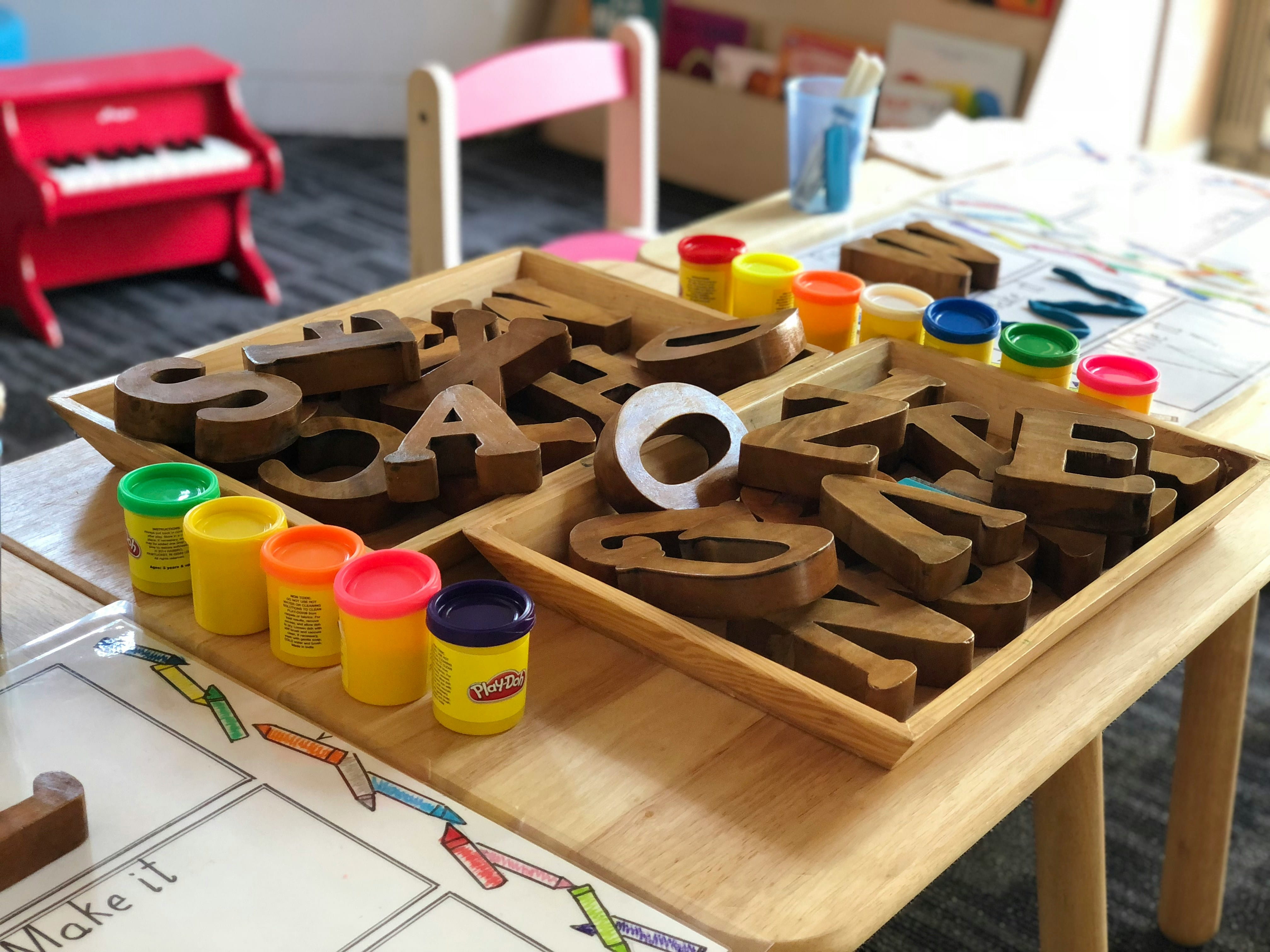 Wooden Letters and Play Doh on a table.