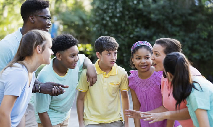 six school children outside with teacher getting instructions