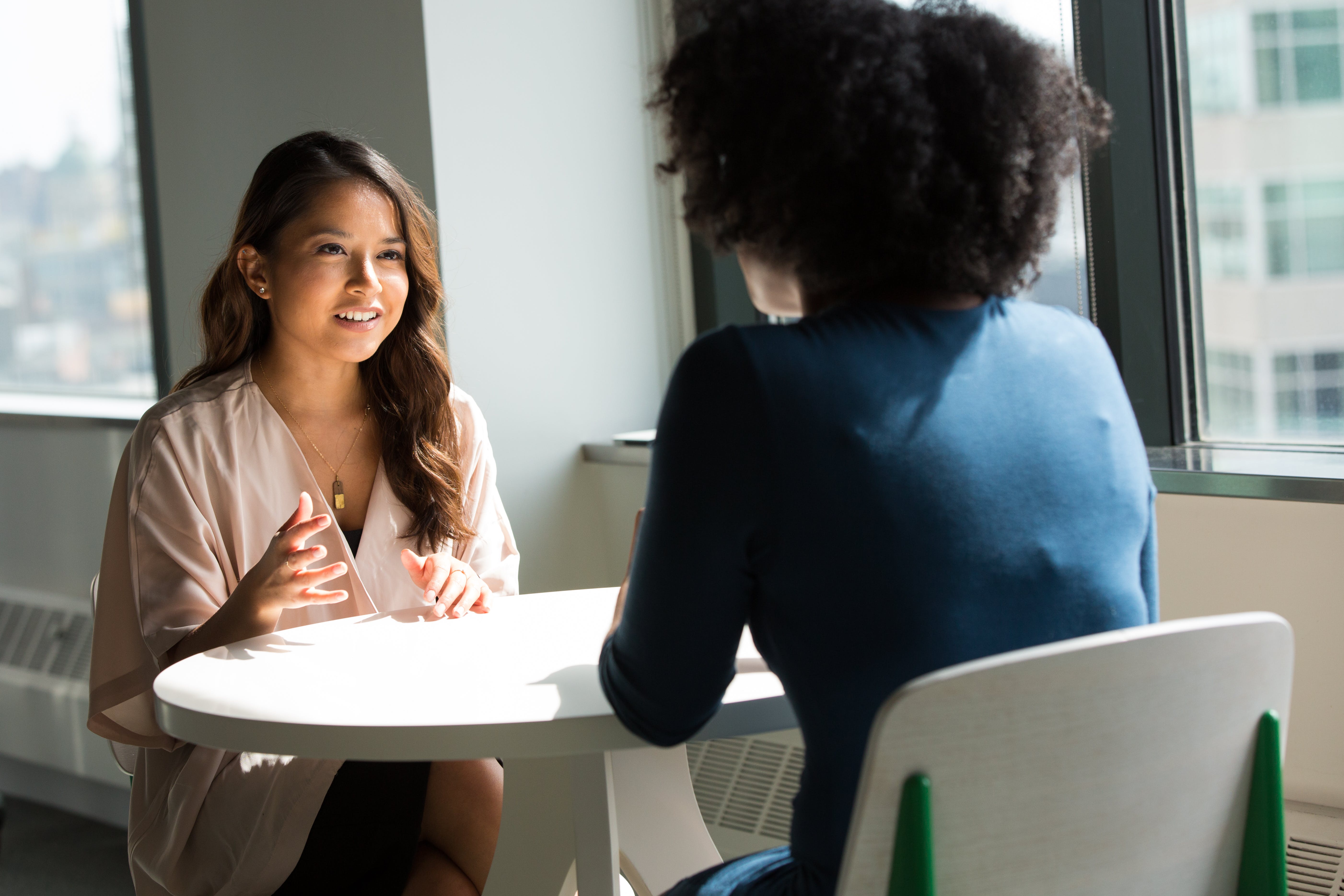 Two people sitting at a table talking.