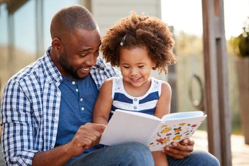 Adult and child reading outdoors