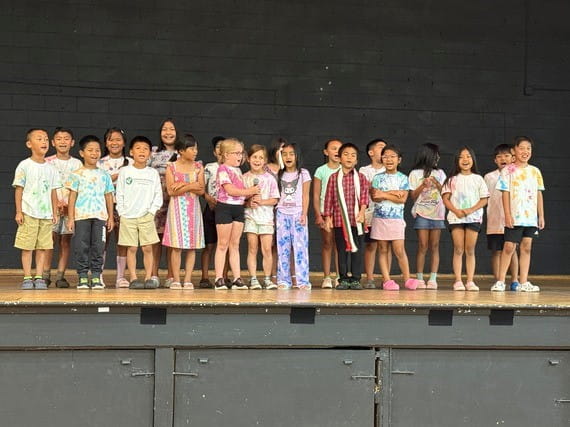 Second and third grade students proudly recite the Burmese alphabet and numerics during today's celebration event, reflecting the program's emphasis on language learning.